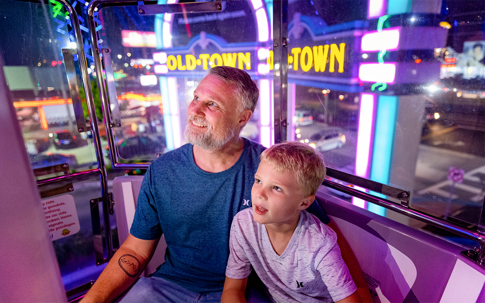 Guests enjoying a ride at Old Town, Orlando with neon lights in the background.