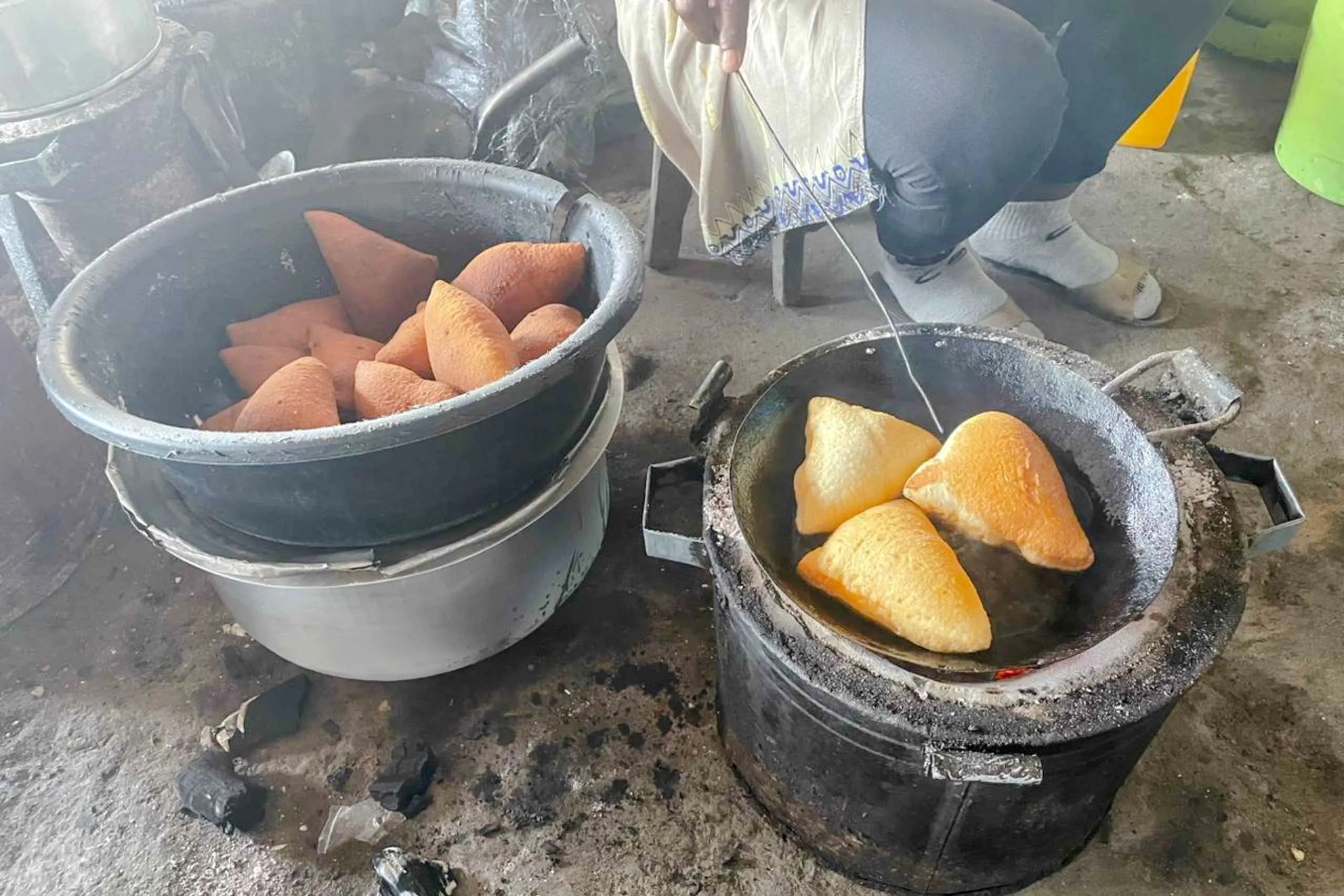 Fried pastries cooking in a pan during Dar es Salaam night tour with dinner, Zanzibar.