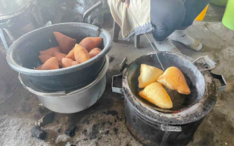 Fried pastries cooking in a pan during Dar es Salaam night tour with dinner, Zanzibar.