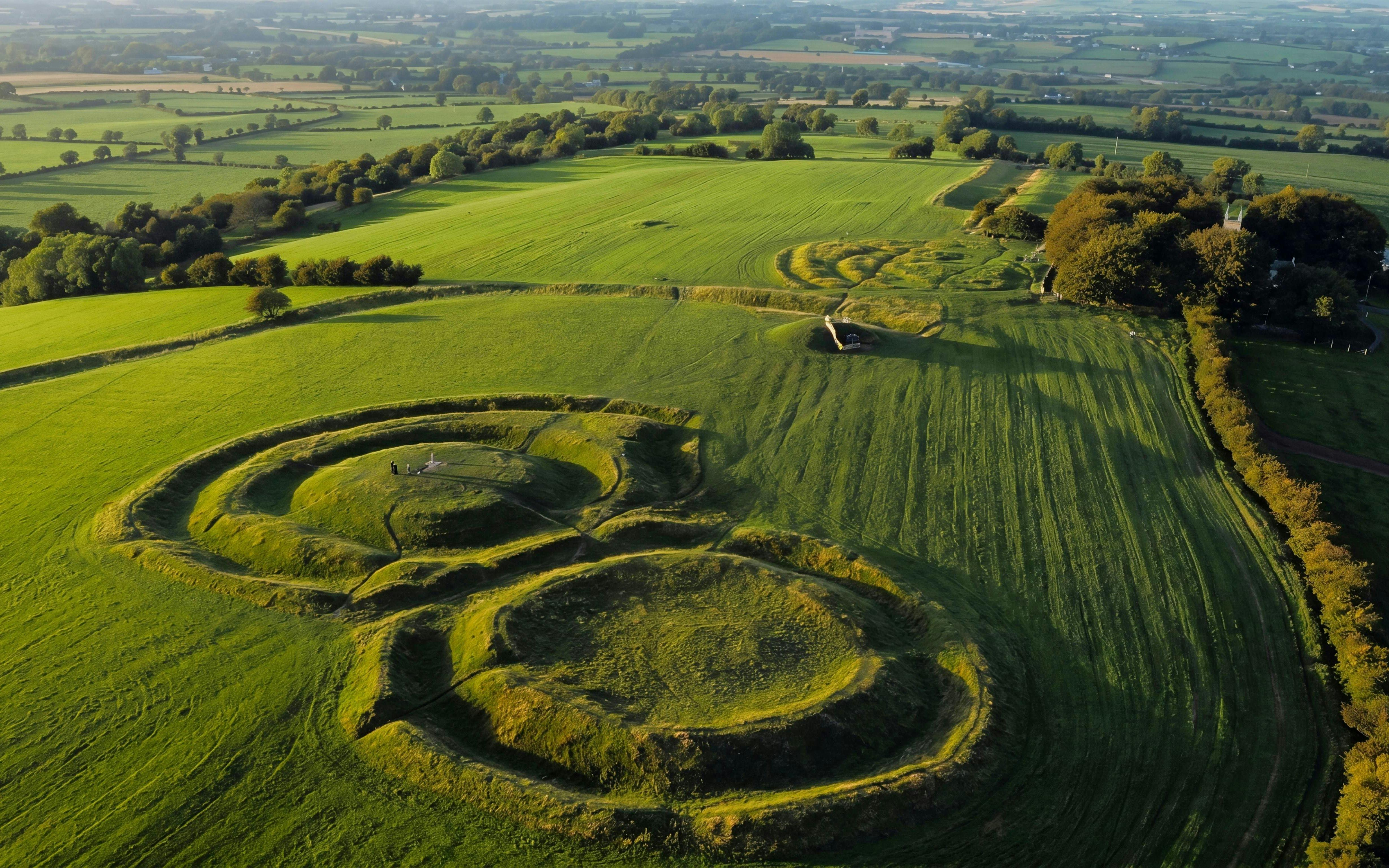 Aerial view of the Hill of Tara, Ireland, featuring ancient earthworks and lush green fields.