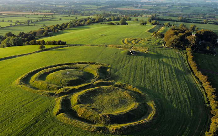 Aerial view of the Hill of Tara, Ireland, featuring ancient earthworks and lush green fields.