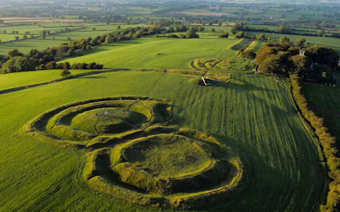 Aerial view of the Hill of Tara, Ireland, featuring ancient earthworks and lush green fields.