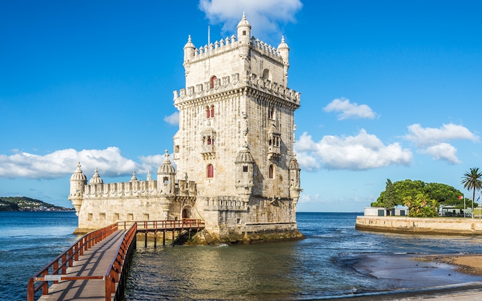 Belem Tower in Lisbon with a wooden walkway over the Tagus River.