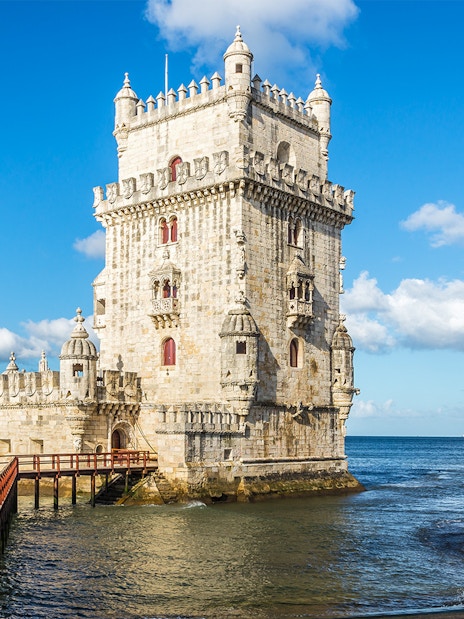 Belem Tower in Lisbon with a wooden walkway over the Tagus River.