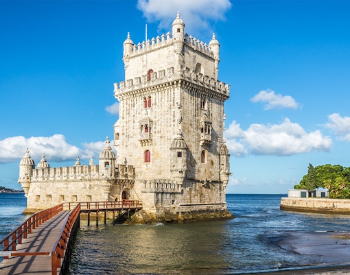 Belem Tower in Lisbon with a wooden walkway over the Tagus River.
