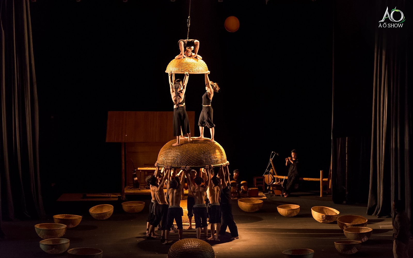 Performers balancing on bamboo structures during AO show.