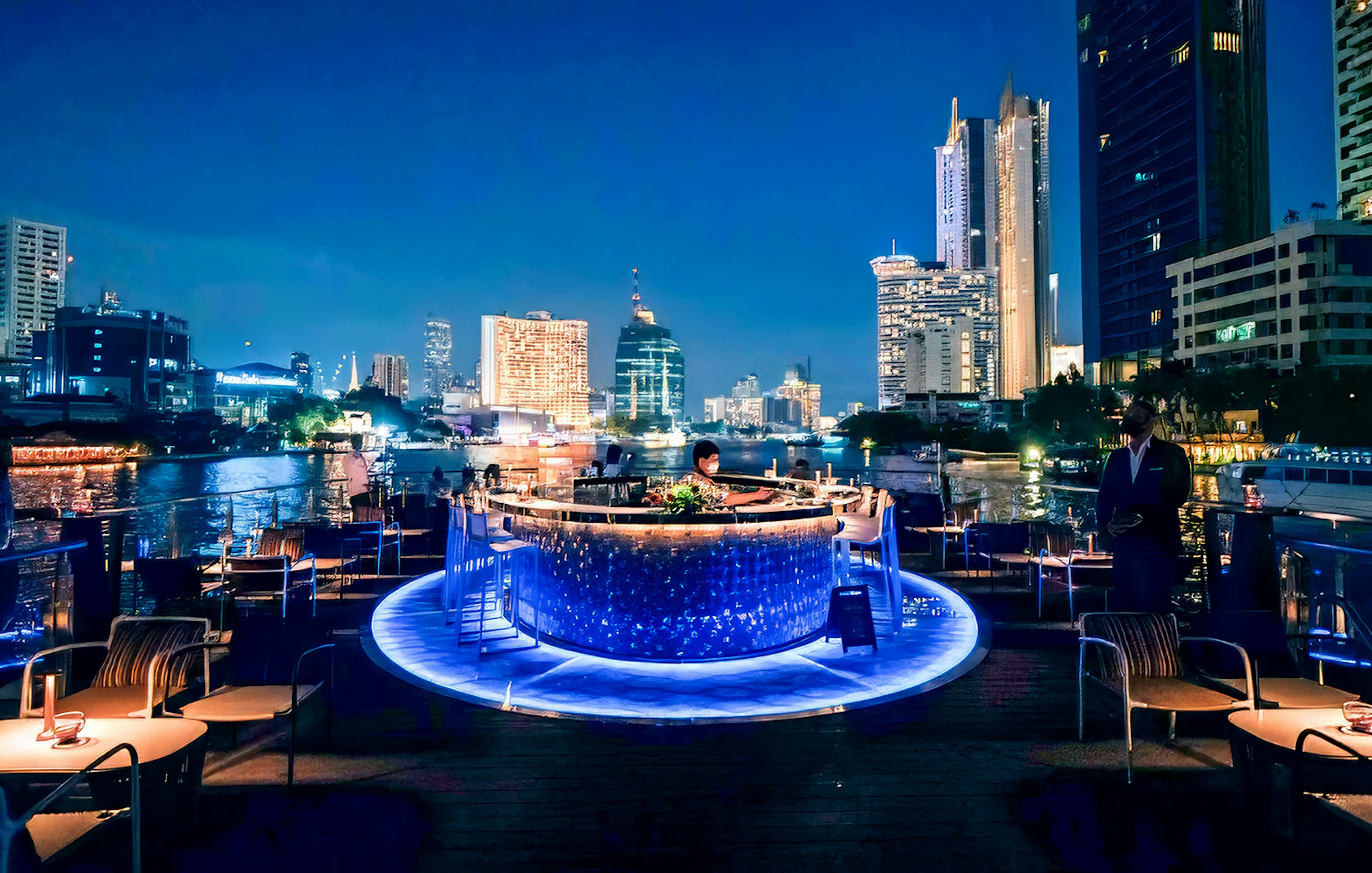 On-deck bar of the Saffron Luxury cruise with Bangkok skyline at night.