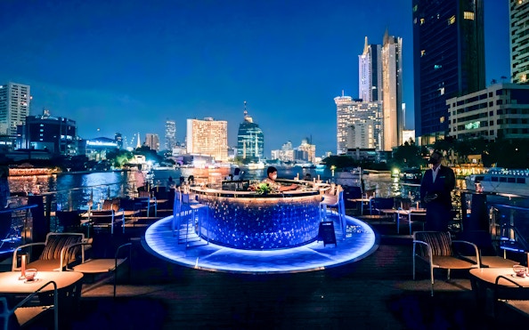 On-deck bar of the Saffron Luxury cruise with Bangkok skyline at night.