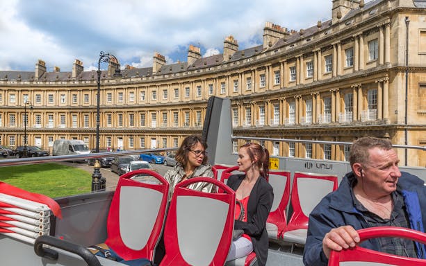Open-top bus tour passing the Circus in Bath, England.