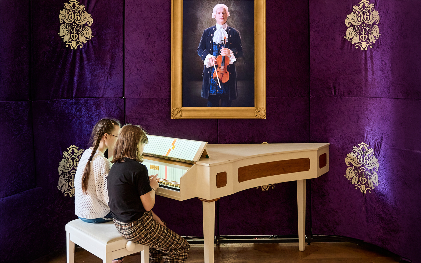 Children playing a harpsichord at Prague Mozart Interactive Museum.