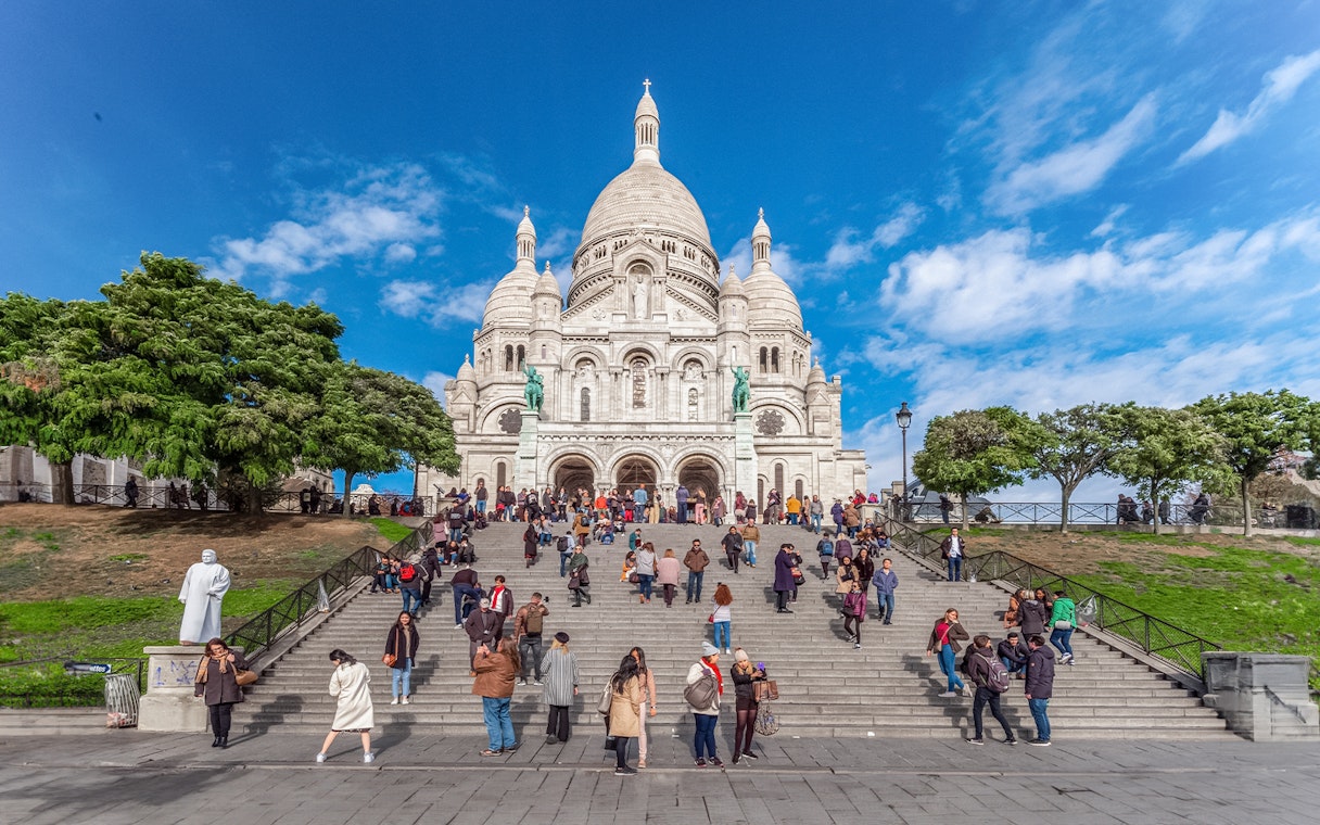 Basilica of the Sacred Heart with visitors on steps during Montmartre Train tour.