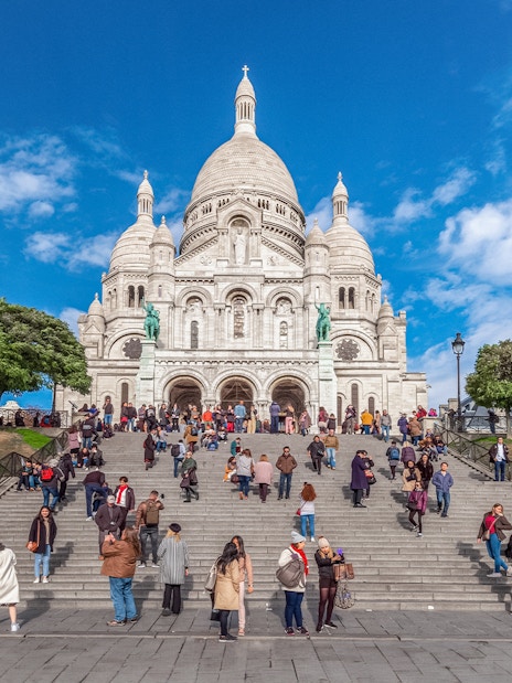 Basilica of the Sacred Heart with visitors on steps during Montmartre Train tour.