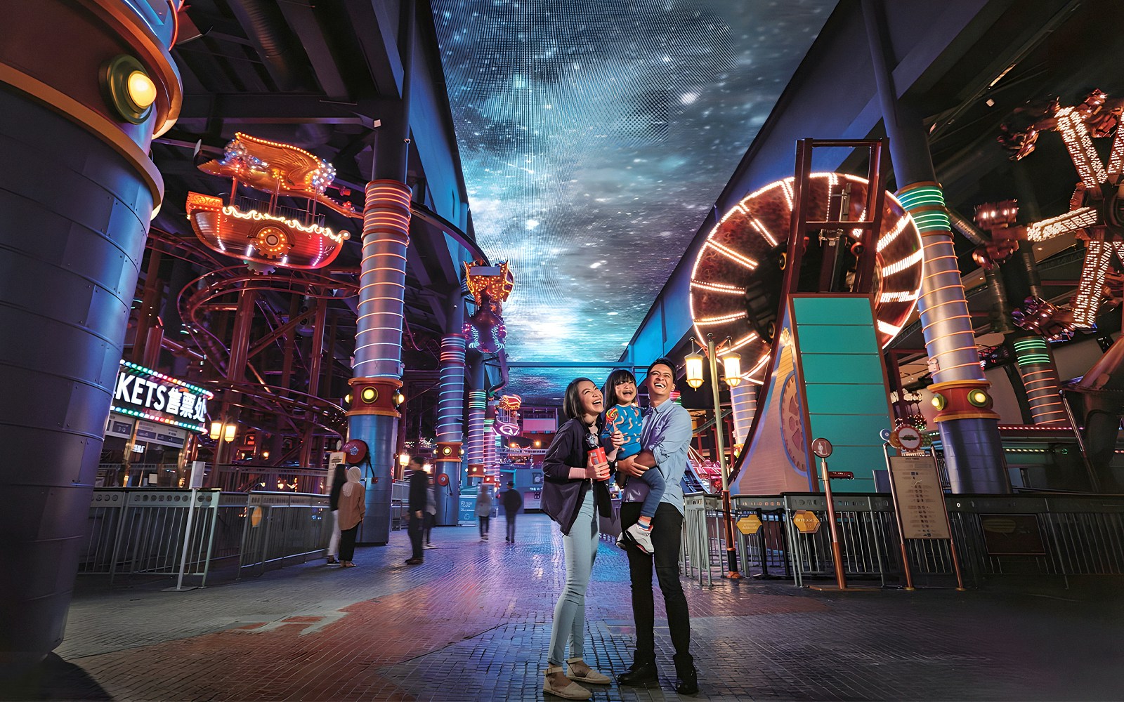 Family enjoying Genting Skytropolis Indoor Theme Park with vibrant lights and attractions.