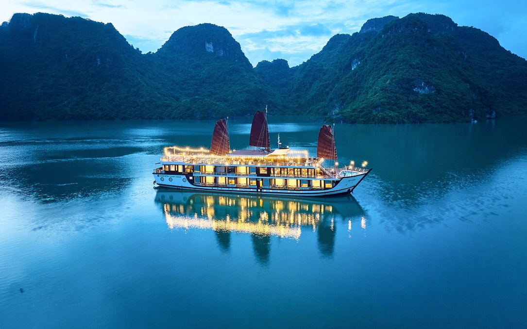 Aerial view of Amanda Luxury Cruise illuminated at night on tranquil waters.