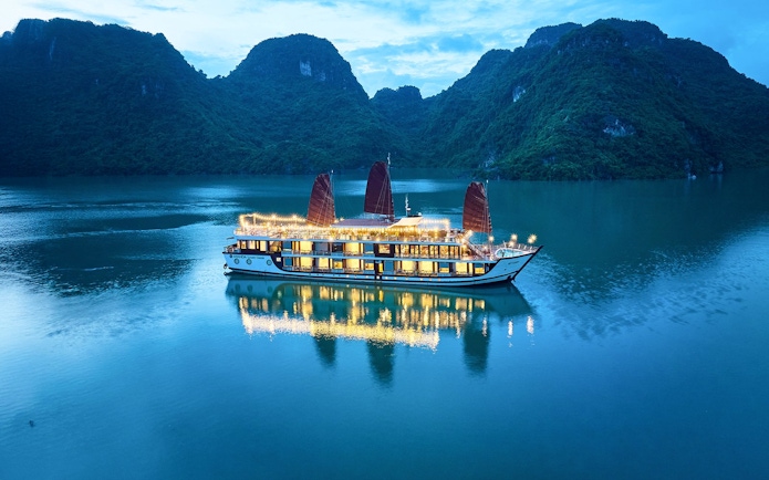 Aerial view of Amanda Luxury Cruise illuminated at night on tranquil waters.
