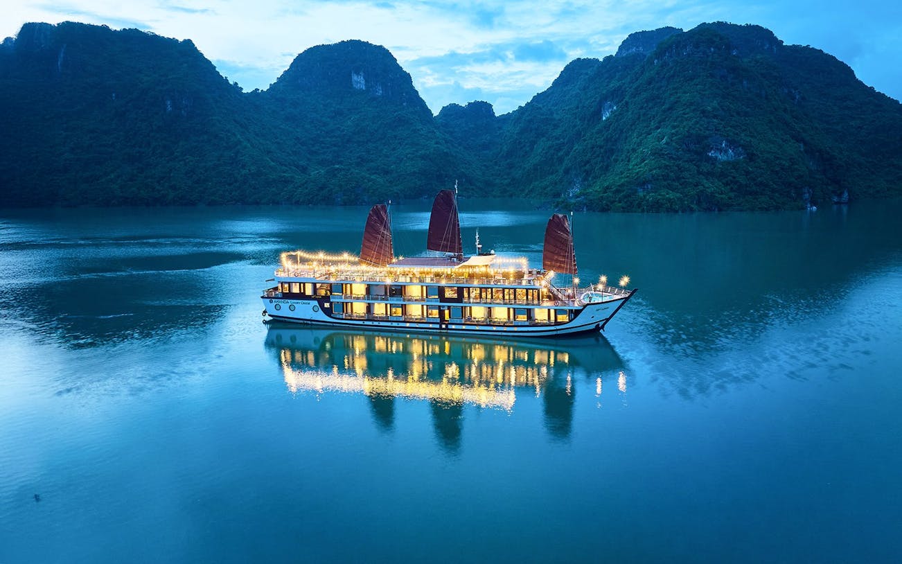 Aerial view of Amanda Luxury Cruise illuminated at night on tranquil waters.