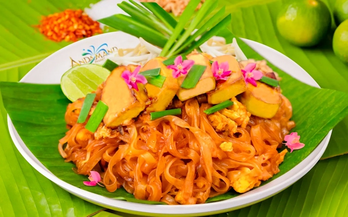 Pad Thai dish with tofu, lime, and flowers at Andamanda Phuket Water Park.