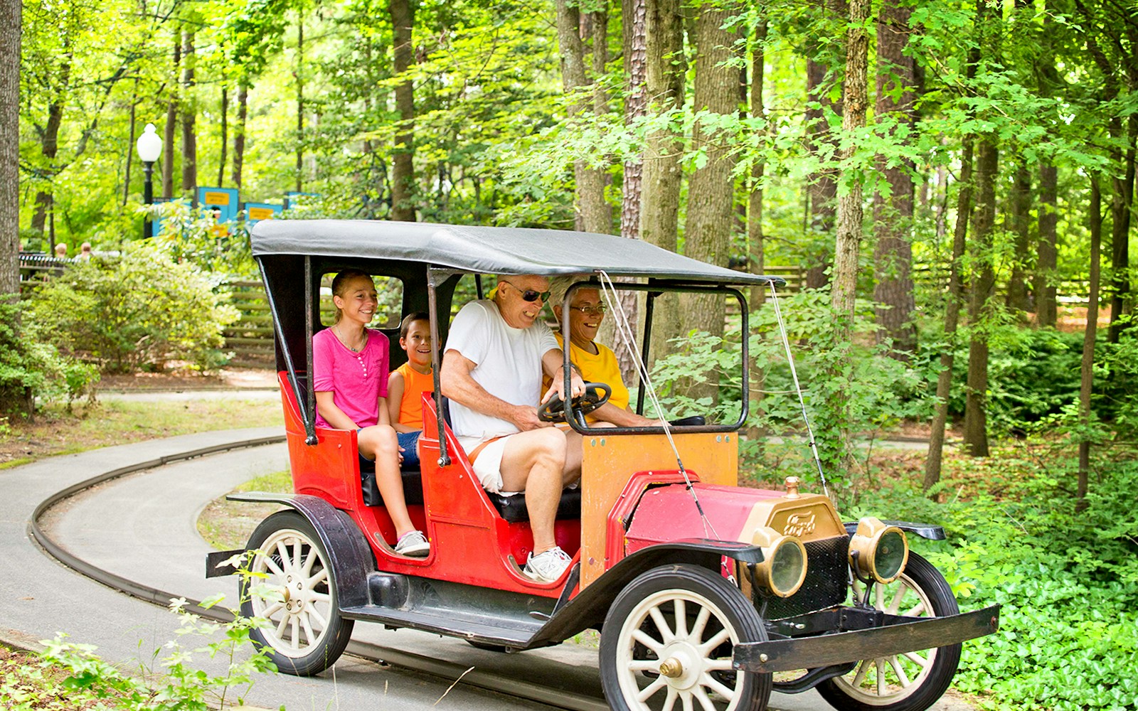Family enjoying a vintage car ride on Blue Ridge Tollway at Six Flags King's Dominion.