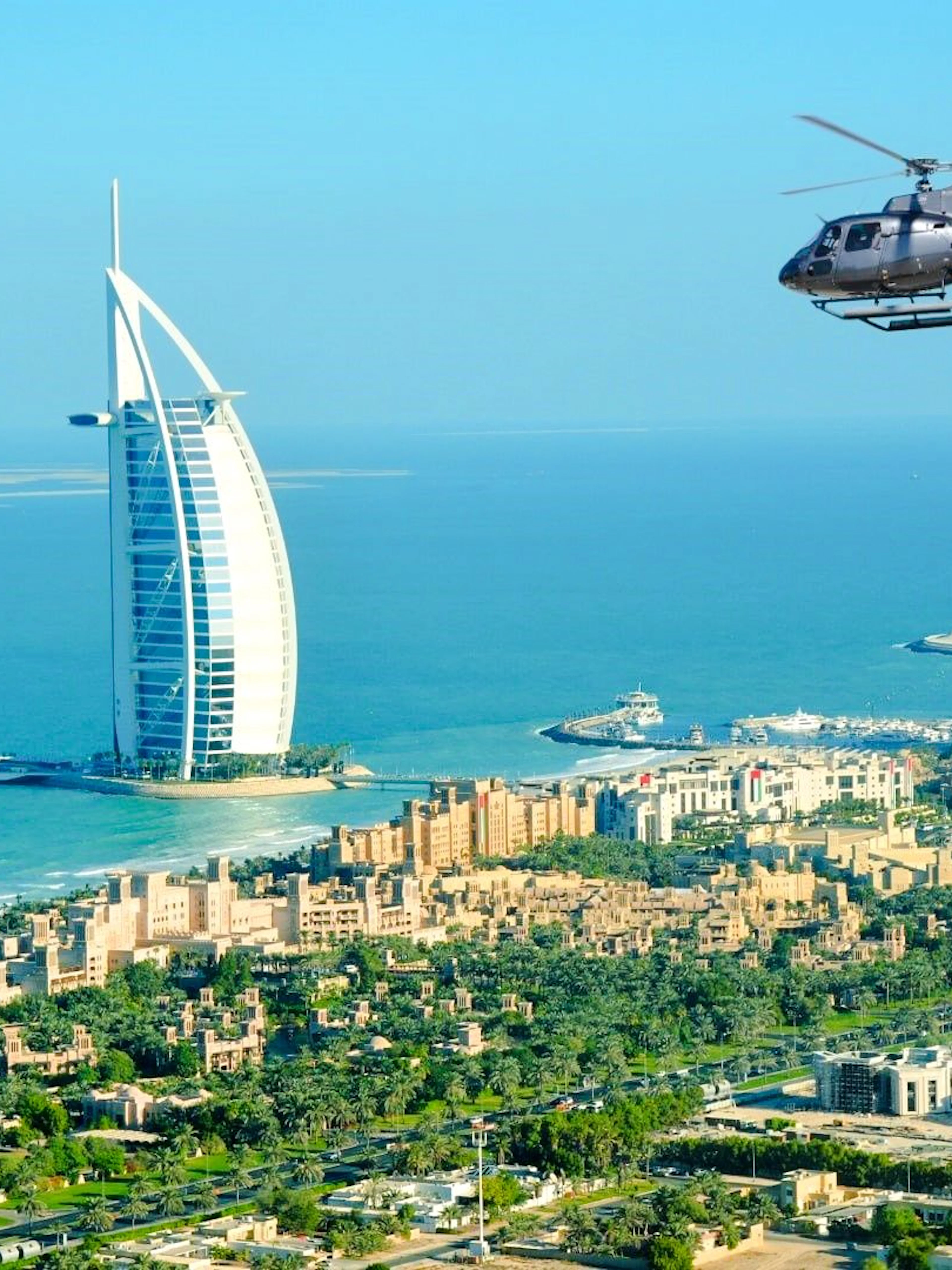 Helicopter flying over Burj Al Arab in Dubai during private tour.