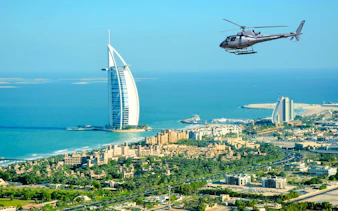 Helicopter flying over Burj Al Arab in Dubai during private tour.