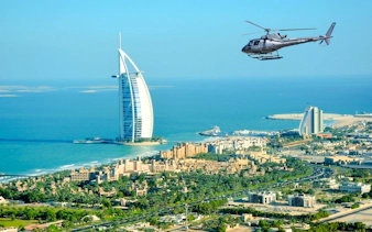 Helicopter flying over Burj Al Arab in Dubai during private tour.