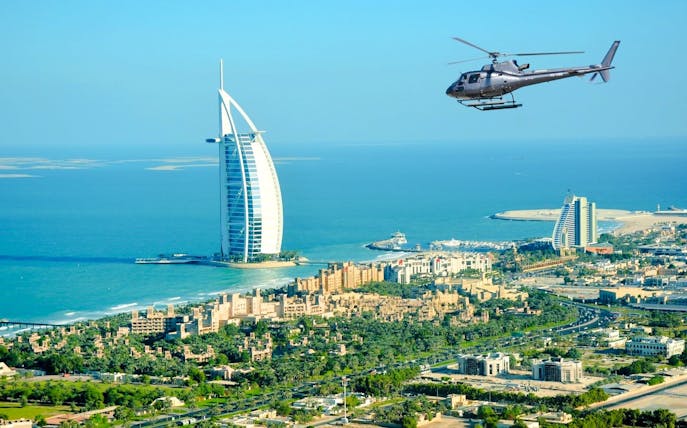 Helicopter flying over Burj Al Arab in Dubai during private tour.