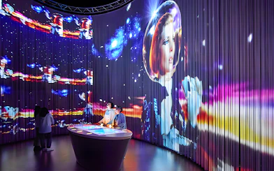 Visitors at Lavazza Museum in Turin viewing immersive space-themed exhibit.