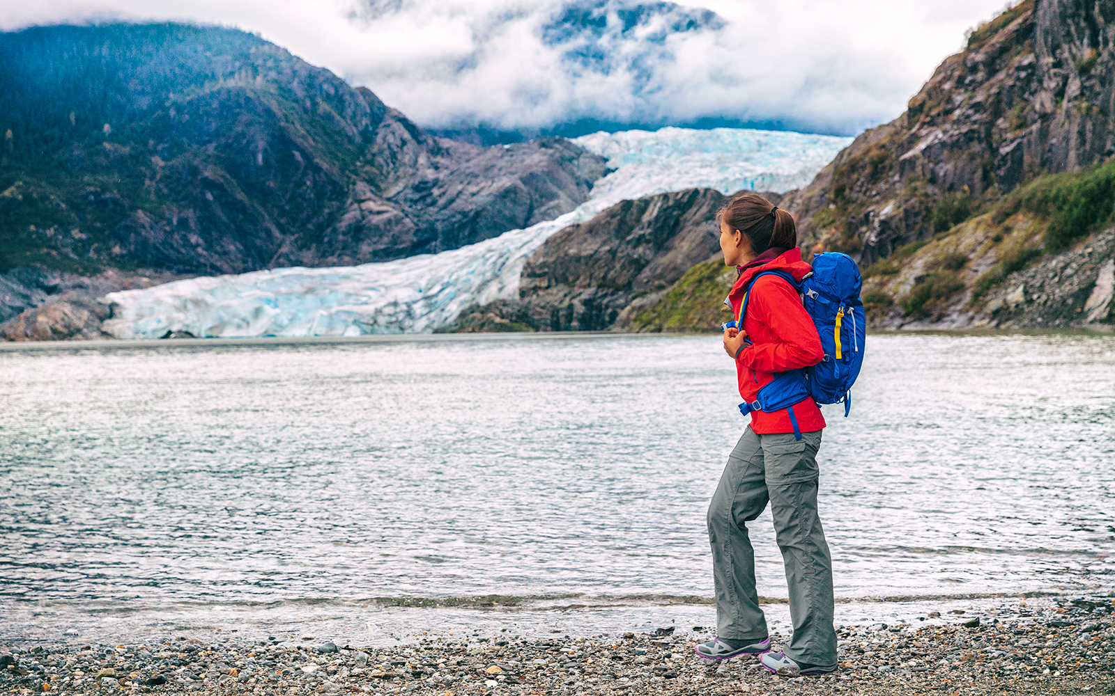 Traveler with backpack near Mendenhall Glacier in Juneau, Alaska.