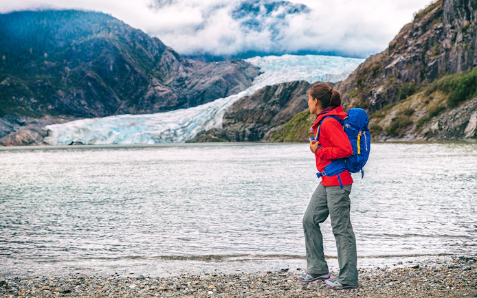 Traveler with backpack near Mendenhall Glacier in Juneau, Alaska.
