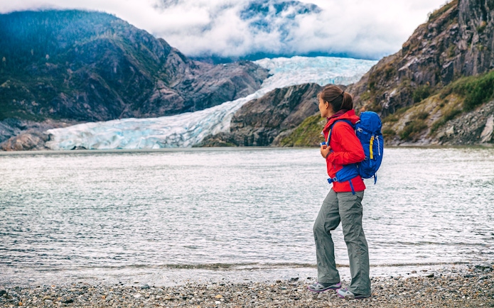 Traveler with backpack near Mendenhall Glacier in Juneau, Alaska.