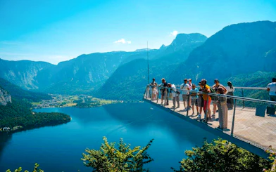 Visitors on Hallstatt Skywalk overlooking lake and mountains, part of Salzburg private tour.