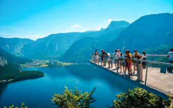 Visitors on Hallstatt Skywalk overlooking lake and mountains, part of Salzburg private tour.