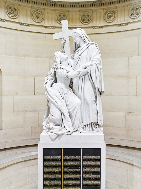 Statue inside Expiatory Chapel, Paris, depicting a kneeling figure holding a cross.