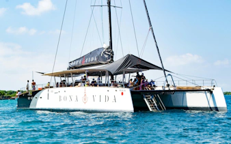 Catamaran with passengers on Rosario Islands cruise in clear blue water.