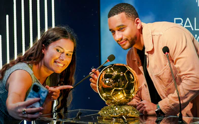 Visitors taking a selfie with a Ballon d'Or replica at Grévin Paris Wax Museum.