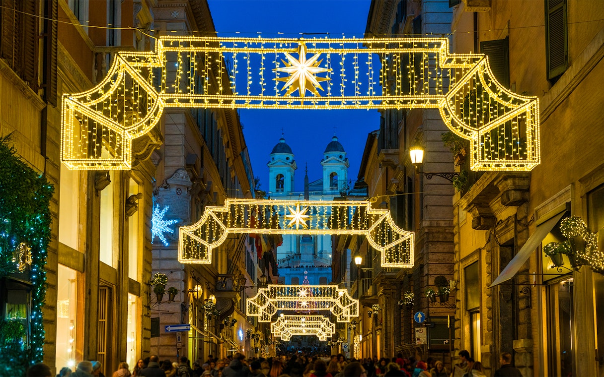 Christmas lights adorn a street in Rome with the Spanish Steps in the background.