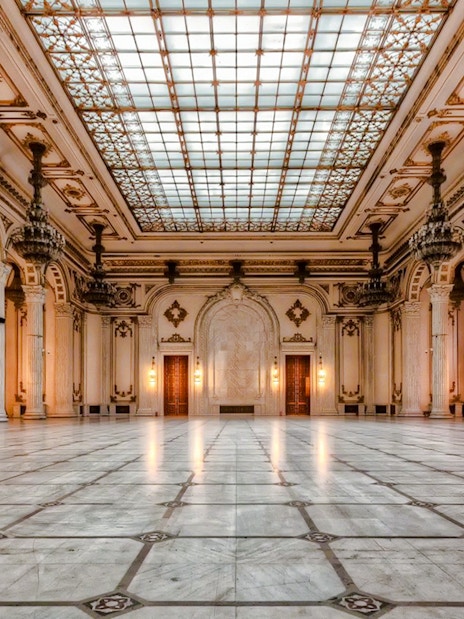 Interior of the Palace of Parliament in Bucharest with ornate columns and chandeliers.