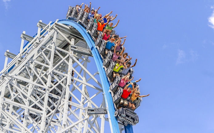 Roller coaster descent at Six Flags Over Georgia with excited riders.