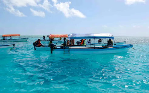 Boats with tourists on a fishing adventure in turquoise waters, Zanzibar.