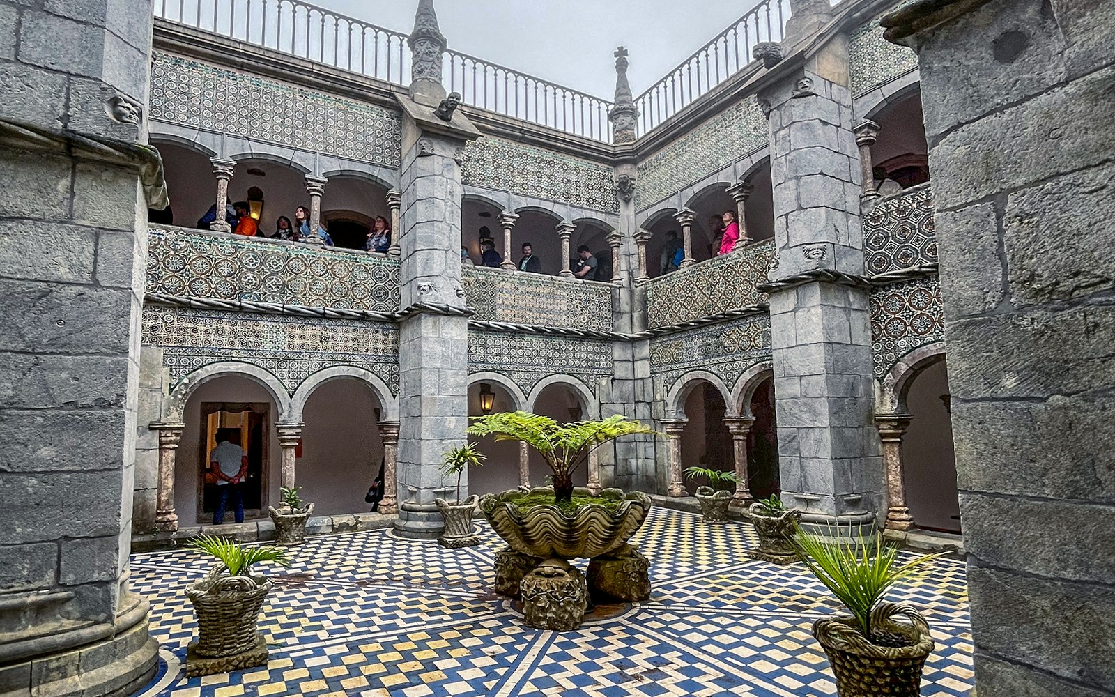Pena Palace's Manueline cloister with intricate arches and stone carvings in Sintra, Portugal.