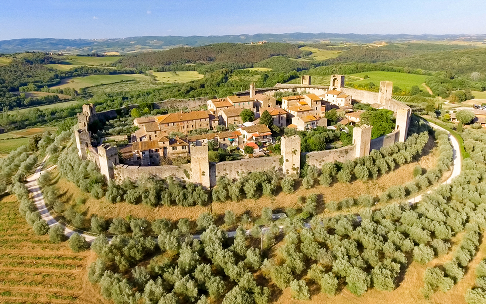 Aerial view of Monteriggioni's medieval walls and surrounding Tuscan landscape.