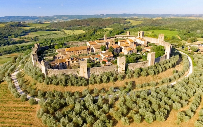 Aerial view of Monteriggioni's medieval walls and surrounding Tuscan landscape.