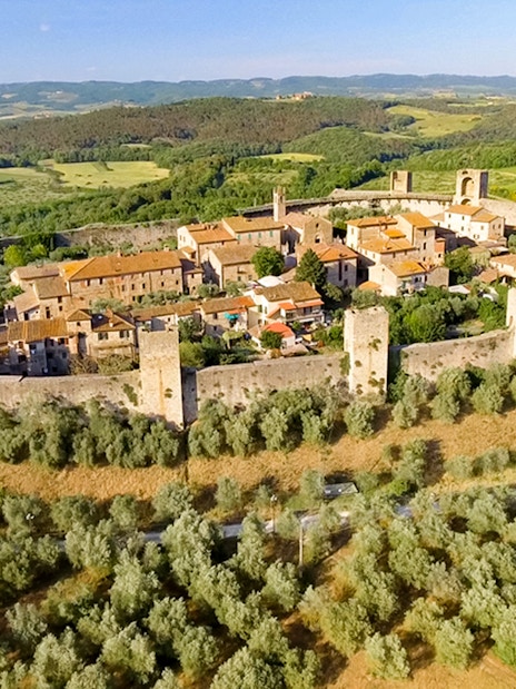 Aerial view of Monteriggioni's medieval walls and surrounding Tuscan landscape.