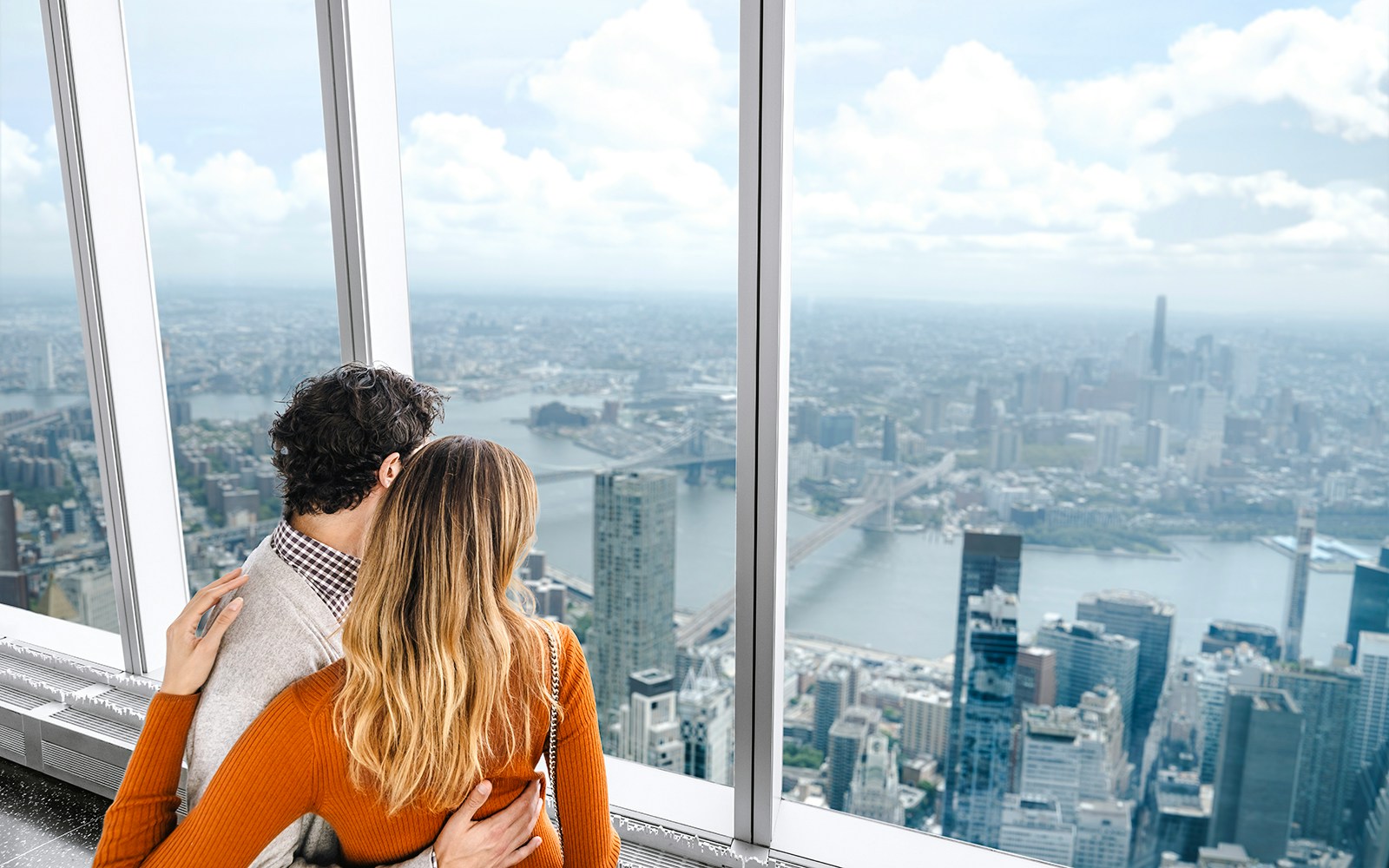 Couple enjoying New York City skyline view from One World Observatory.