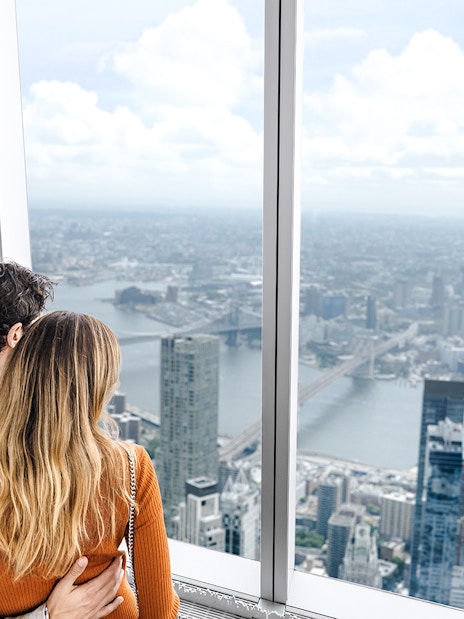 Couple enjoying New York City skyline view from One World Observatory.