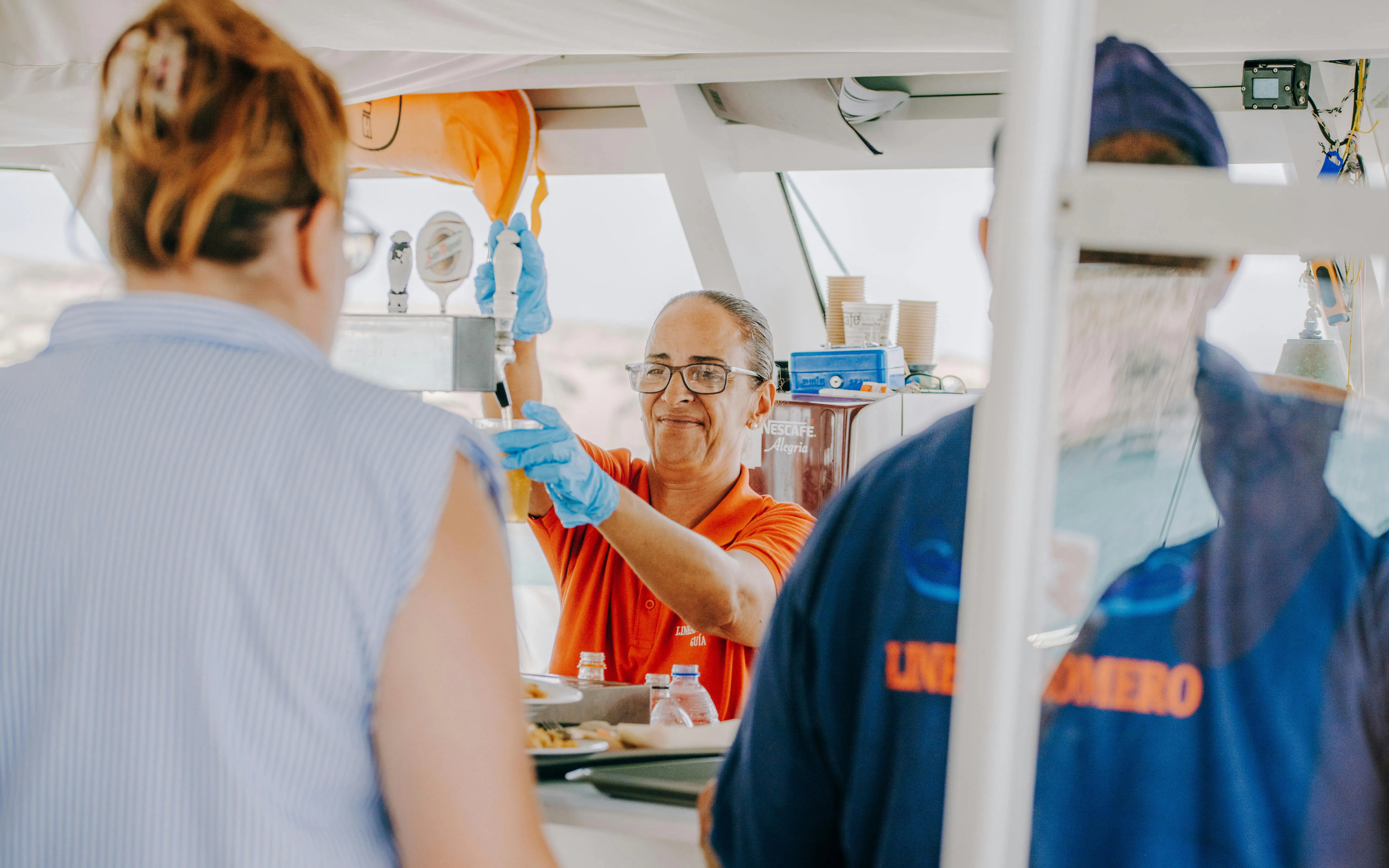 Server pouring drinks on La Graciosa Island cruise with lunch.