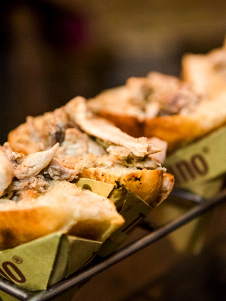 Trapizzino filled with chicken on a serving rack in Rome, Italy.