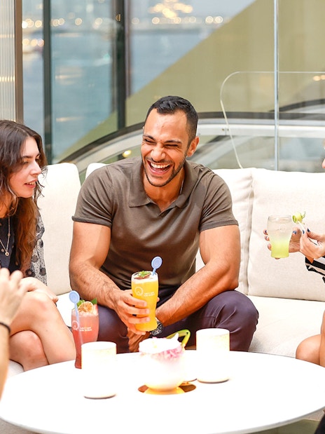 Group of people enjoying drinks and conversation indoors.