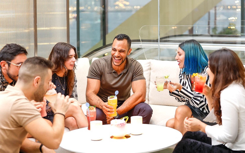 Group of people enjoying drinks and conversation indoors.