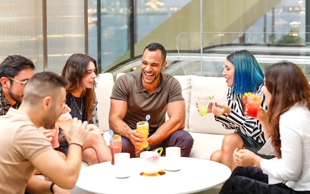 Group of people enjoying drinks and conversation indoors.